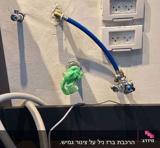 צינור כחול מחובר לברז על קיר